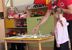 Dziewczynka robi eksperyment z jajkiem