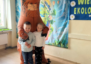 Dzieci pozują do zdjęcia z dinozaurem