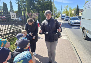 Dzieci wręczają flagi przechodniom