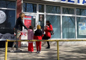 Dzieci wręczają flagi przechodniom