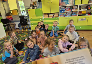 Dzieci słuchają jak czyta nauczyciel