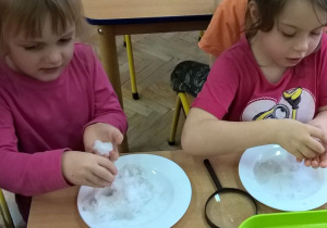 Dziewczynki bawią się śniegiem