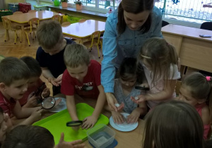 Dzieci ogladają śnieg przez lupy