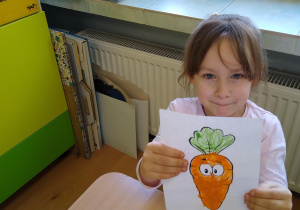 Dziewczynka pokazuje swoją pracę
