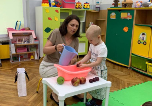 Chłopiec myje śliwkę
