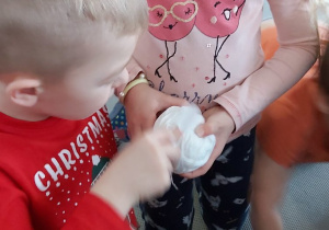 Przedszkolaki pocierają plastikową łyżeczkę o wełnę