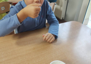 Chłopiec smakuje ekologiczny jogurt