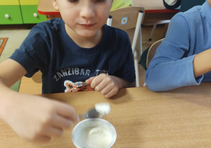 Chłopiec smakuje jogurt