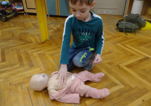 Chłopiec ćwiczy udzielanie pierwszej pomocy