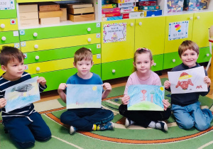 Dzieci pokazują swoje rysunki