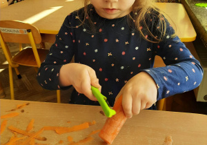 Dziewczynka obiera marchewkę