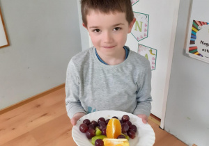 Chłopiec prezentuje owoce