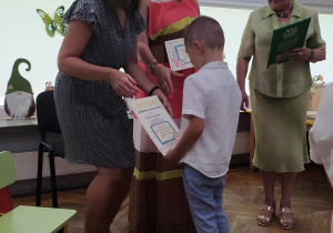 Chłopiec odbiera dyplom i nagrodę