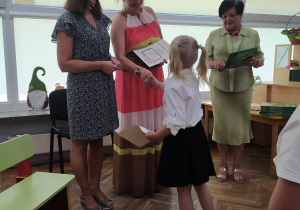 Dziewczynka odbiera dyplom i nagrodę