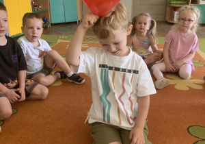 Chłopiec pociera balonem włosy