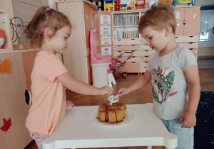 Dzieci posypują ciasto cukrem