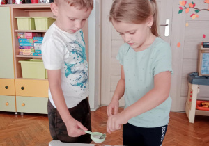 Dzieci posypują ciasto cukrem