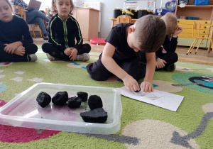 Chłopiec rysuje węglem