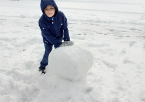 Chłopiec lepi kule ze śniegu