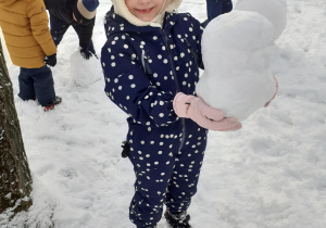 Dziewczynka bawi się śniegiem