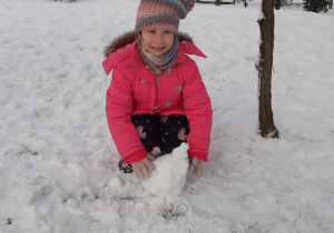 Dziewczynka bawi śię śniegiem