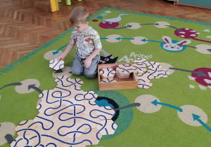 Chłopiec układa drewniane puzzle