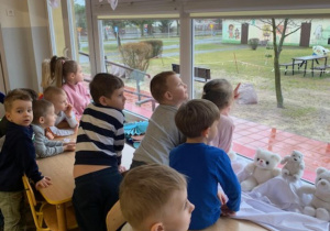 Przedszkolaki obserwują ptaki w ogrodzie przedszkolnym
