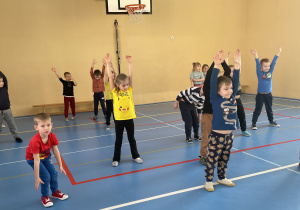 Przedszkolaki ćwiczą na sali gimnastyczne w SP nr 12