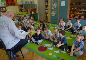 Przedszkolaki zasłuchane w czytaną bajkę