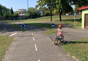 Dziewczynka jedzie rowerem w Miasteczku Ruchu Drogowego