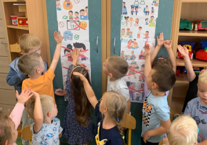 Dzieci oglądają plansze edukacyjne na temat ochrony małoletnich