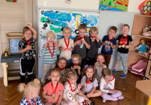 Dzieci pozują do zdjęcia z medalami