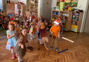 Dzieci rzucają kasztanami do pojemników