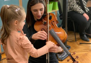 Dziewczynka próbuje grać na instrumencie