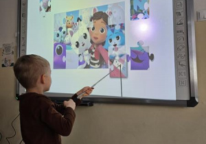 Dzieci układają puzzle na tablicy interaktywnej