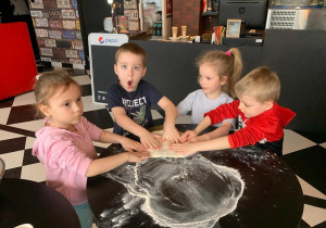 Dzieci wygniatają ciasto na pizzę