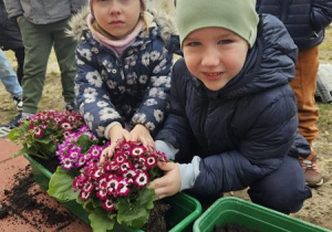 Chłopiec i dziewczynka sadzą kwiatki