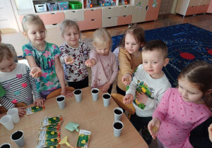 Dzieci przygotowują nasiona owsa do siewu