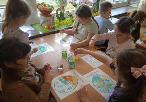 Dzieci za pomocą pipet i wody tworzą obrazki