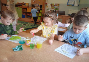 Dzieci za pomocą pipet i wody tworzą obrazki