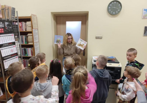 Pani pokazuje dzieciom książki dla dzieci