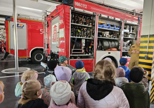 Strażak pokazuje co znajduje się w wyposażeniu wozu