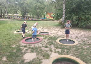 Dzieci skaczą na trampolinach