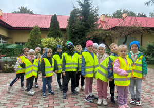 Dzieci pozują do zdjęcia w kamizelkach odblaskowych