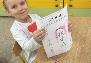 Dziewczynka pozuje ze skończoną kartą pracy