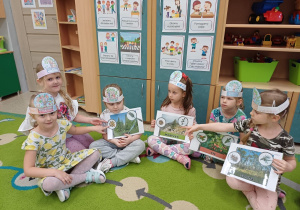 Dzieci z grupy Tropiciele pozują z planszami dydaktycznymi