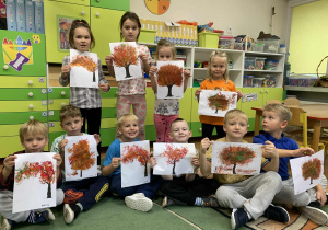 Dzieci pozują do zdjęcia z wykonanymi pracami