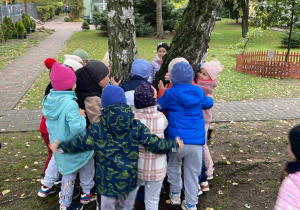 Dzieci przytulają drzewo