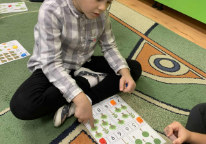 Dziewczynka układa klocki na odpowiedniej liczbie