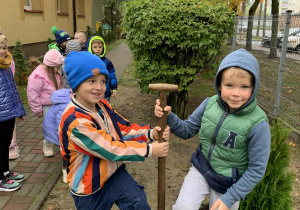 Chłopcy pozują do zdjęcia z łopatą do sadzenia drzew